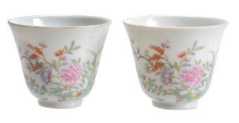 A pair of famille rose wine cups, each of small, conical form resting on a short foot, decorated in