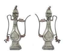 A pair of pewter ewers, 19th century, of Middle Eastern metalwork form with thin, curving handle