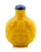 A yellow glass snuff bottle of globular form, carved with a seated figure of Budai amid bats,