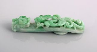 A green jade belt hook, 19th century  or later, the head typically carved as a dragon?s, the shaft