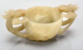 A pale celadon jade ?chilong cup?,  18th century, the deep U-shaped body carved and pierced with