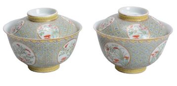A pair of Chinese famille rose bowls and covers, with a wanzi diaper pattern drawn on a yellow