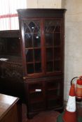 A Georgian style mahogany corner cabinet in two pieces.