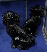 A pair of black pottery hearth dogs; 35cm high