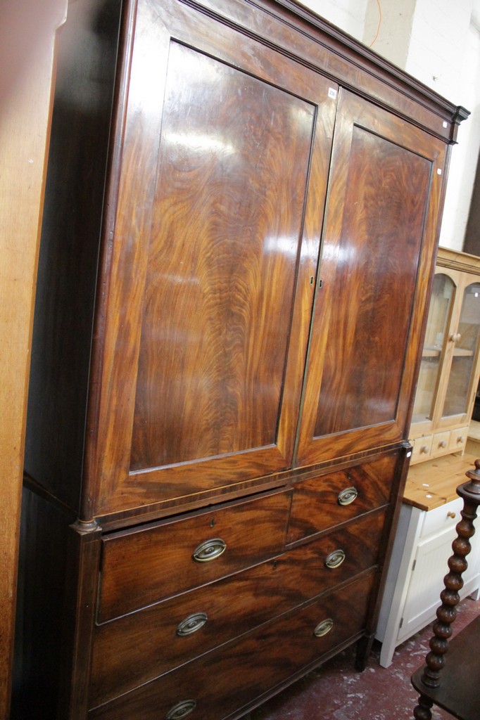 An early 19th Century mahogany linen press the panelled doors flanked by column supports with two