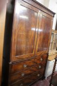 An early 19th Century mahogany linen press the panelled doors flanked by column supports with two