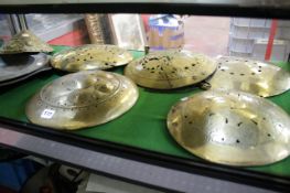 Five Continental brass warming pan covers, a sieve and two pewter plates