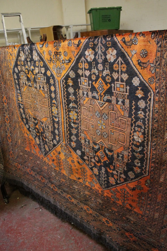 A Pakistani carpet with an orange field