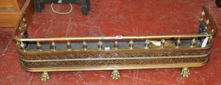 A 19th century pierced brass fire fender and a set of fire irons.