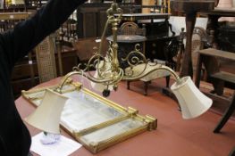 A brass three branch ceiling light with shades