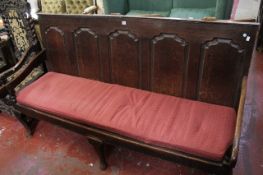 A provincial George III oak settle with a broken arch panelled back.186cm wide.