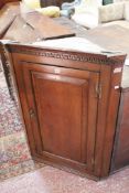 A Georgian oak corner hanging cabinet.