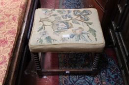 A footstool with tapestry needlework cover on bobbin turned legs