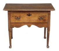 A George III oak lowboy, circa 1770, with shaped top, single drawer and set on circular tapered