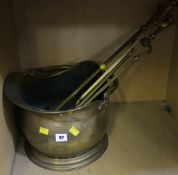 A set of brass fire irons, brass helmet-shaped coal scuttle and pierced brass fender
