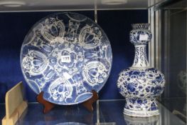 An 18th Century Dutch Delft charger; 30cm in diameter, together with a further Delft shaped vase;