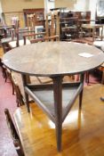 A 19th century circular oak side table on three legs and triangular under tier.