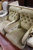 A pair Howard style armchairs in green upholstery with Stranan & Co stamped to the castors.