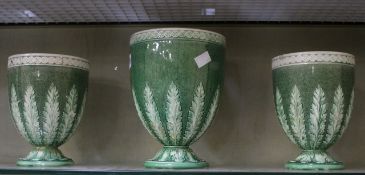 A garniture of three late 18th Century Wedgwood Queens Ware mottled green ground urns sprigged with