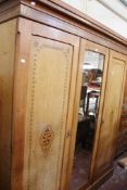 A Victorian mahogany and inlaid wardrobe with central mirror flanked by two cupboards and fitted