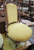 A Victorian walnut and upholstered nursing chair