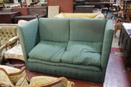 A knole sofa in green damask style upholstery.