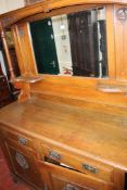 An early 20th century oak sideboard with a raised mirror back 137cm wide.