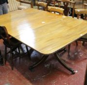 A  mahogany twin pedestal dining table with one additional leaf