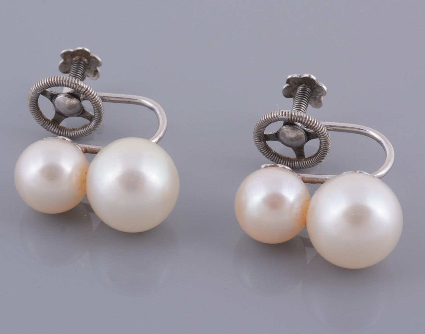 A pair of cultured pearl ear clips , the earrings each set with two...  A pair of cultured pearl ear