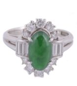 A jadeite and diamond cluster ring , the oval cabochon jadeite panel within...  A jadeite and