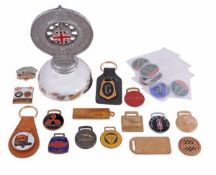 A collection of motoring key fobs and lapel badges, including items for Silverstone, Oldsmobile,