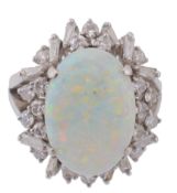 An opal and diamond ring, the oval shaped cabochon opal in a four claw setting  An opal and