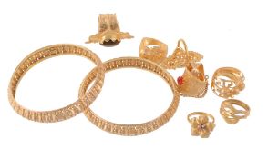 Two gold coloured bangles, the pierced bangles stamped 22k; together with a...  Two gold coloured