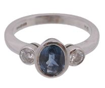 A sapphire and diamond ring, the central collet set oval shaped sapphire...  A sapphire and