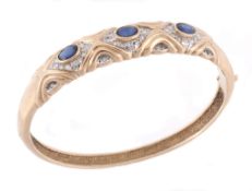 A sapphire and diamond bangle, the hinged bangle set with three collet set...  A sapphire and
