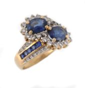 A sapphire and diamond crossover ring, the two oval shaped sapphires within...  A sapphire and