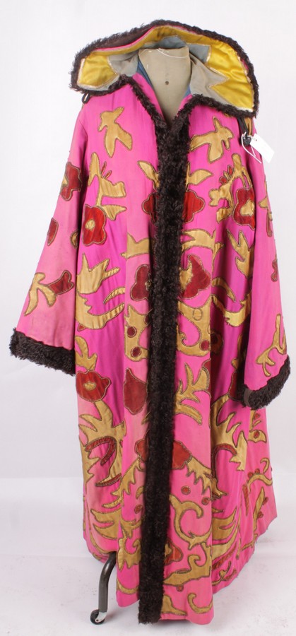 A late 19th century magician`s coat, a full length fuchsia pink coat embellished with applique