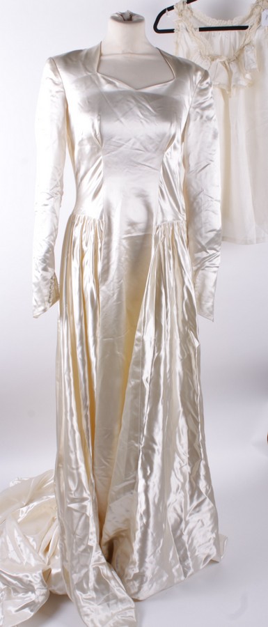 An Edwardian cream silk gown, the bodice decorated with lace and beaded trimming; together with an