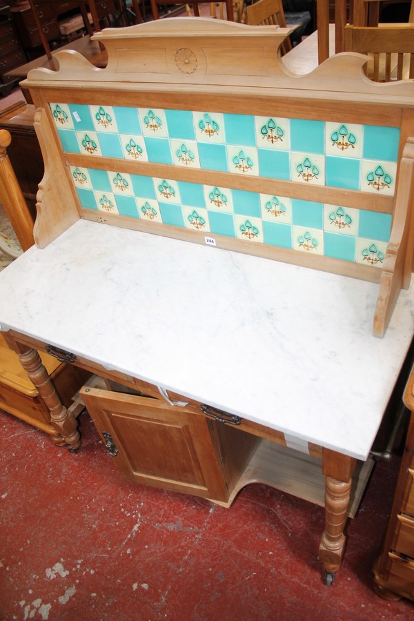 An early 20th Century pine marble topped washstand with a tiled back 107cm wide