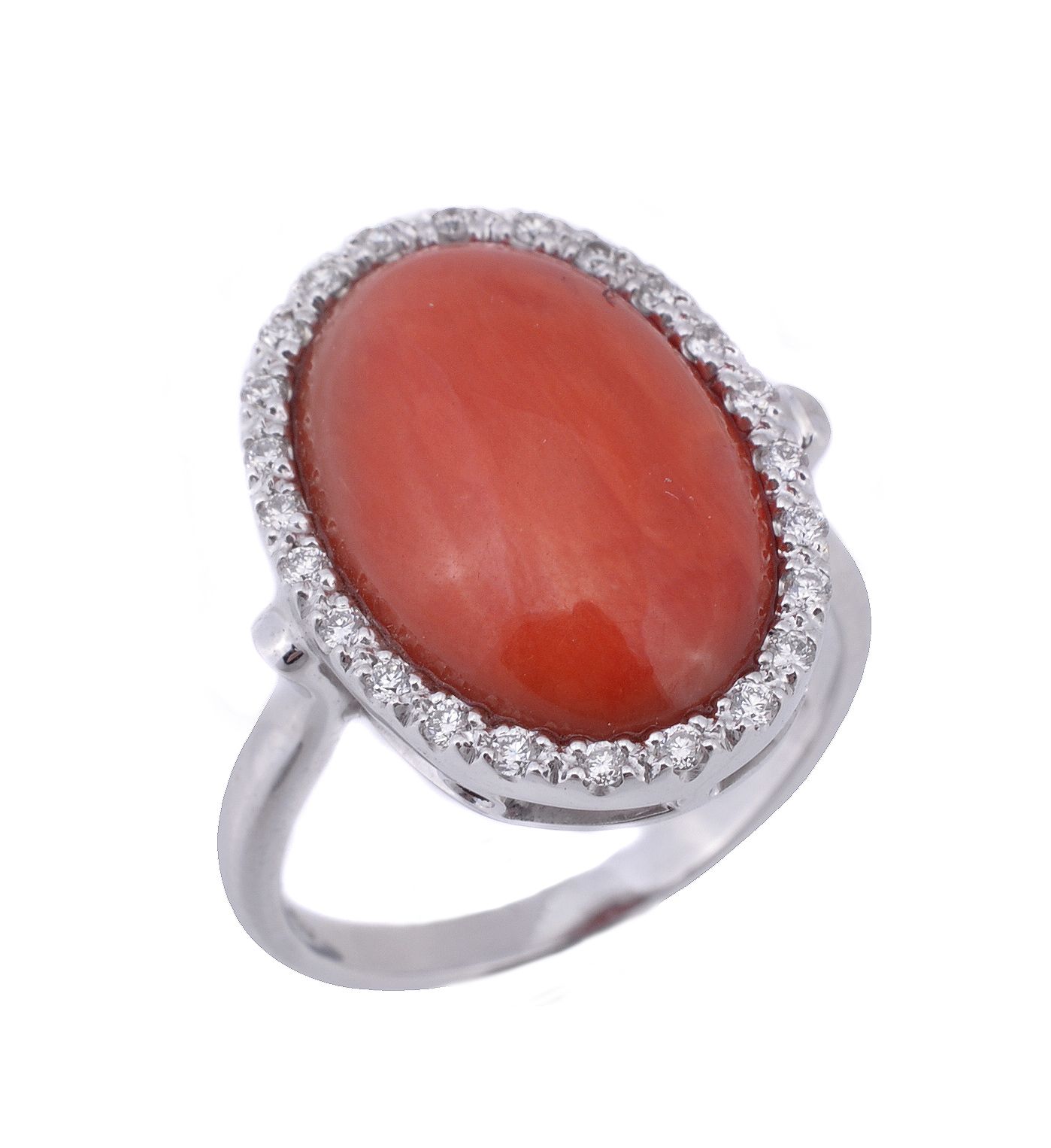 A coral and diamond ring, the oval cabochon coral within a surround of...  A coral and diamond ring,