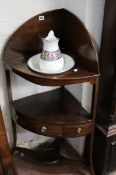 A 19th century mahogany corner wash stand with a jug and bowl.