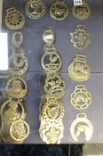A decorative set of 16 horse brasses (8 mounted on leather strap and 8 loose)