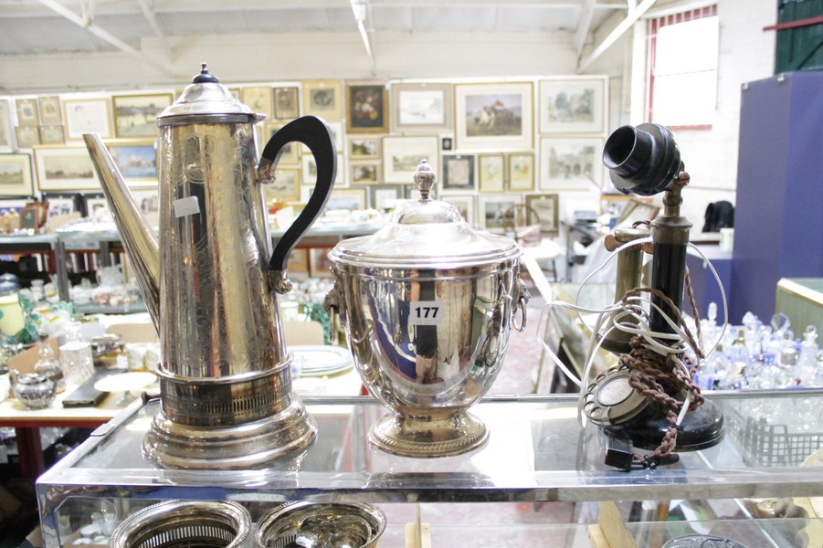 A silverplate kettle on stand, ice bucket with twin lion mask handles, two wine coasters, a toddy