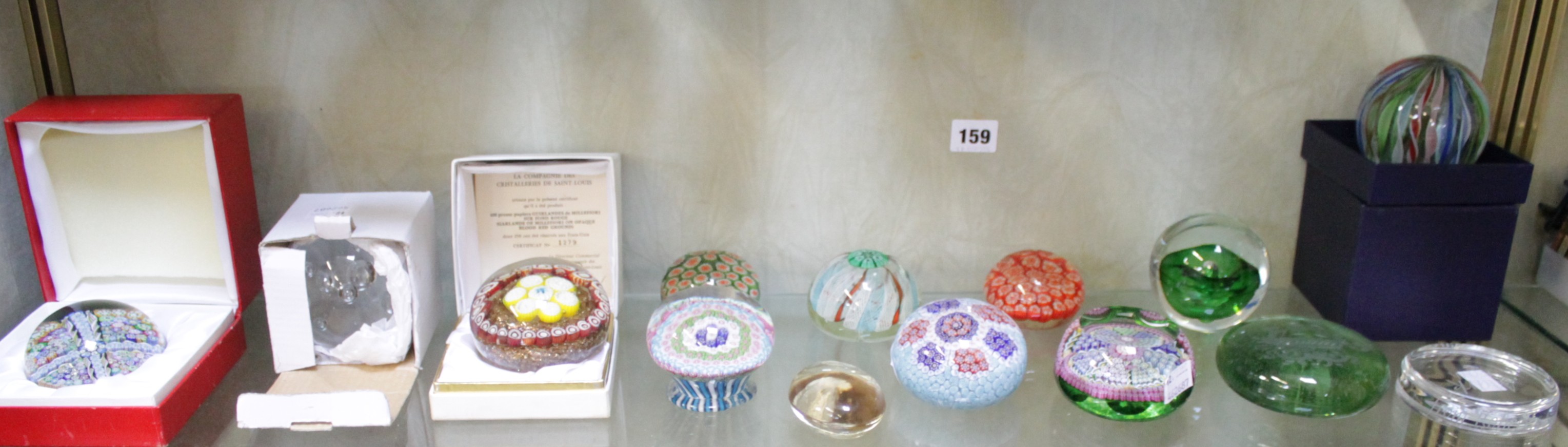 A collection of fourteen glass paperweights including a boxed Baccarat example dated 1997 to the