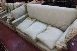 A Knole suite, pre 1950 comprising a three seat drop-end sofa and a pair of wing armchairs, all