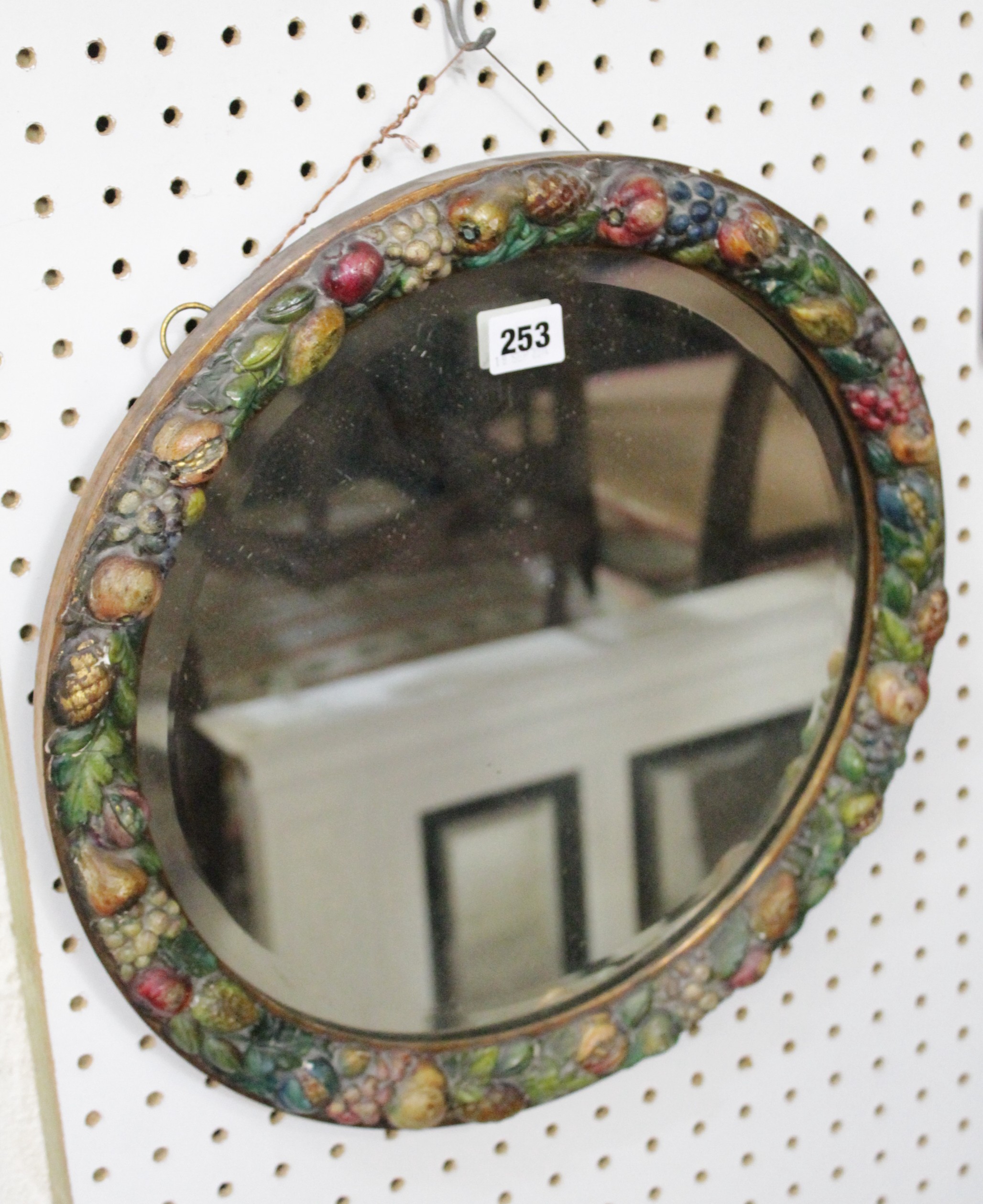 A polychrome decorated circular mirror with bevelled plate 40cm diameter