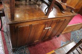 An antique oak cabinet, of rectangular form, with a pair of  moulded and panelled doors on block