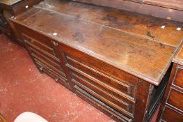 An 18th Century oak mule chest with a hinged lid, fielded panels to the front and two drawers below