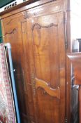 A French 19th century cherrywood armoire with moulded cornice over panelled doors.