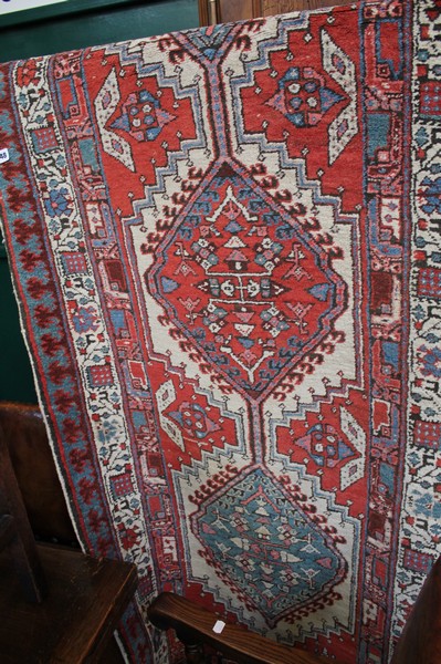 A Persian style runner with interlocking lozenges on a predominately red and blue ground 3 meters